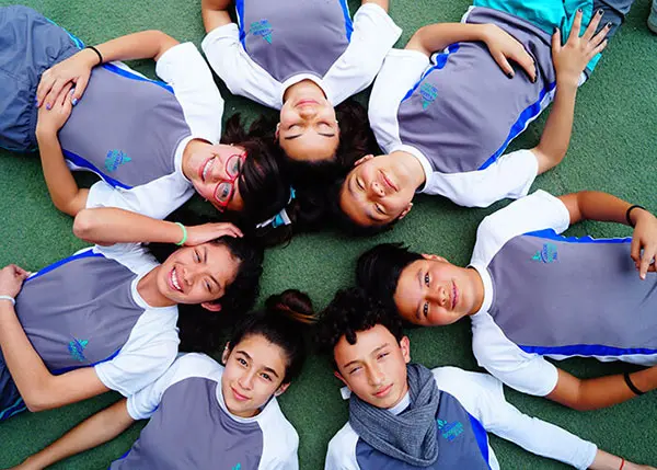 Alumnos felices recostados en círculo en secundaria particular en Cuautitlán Izcalli